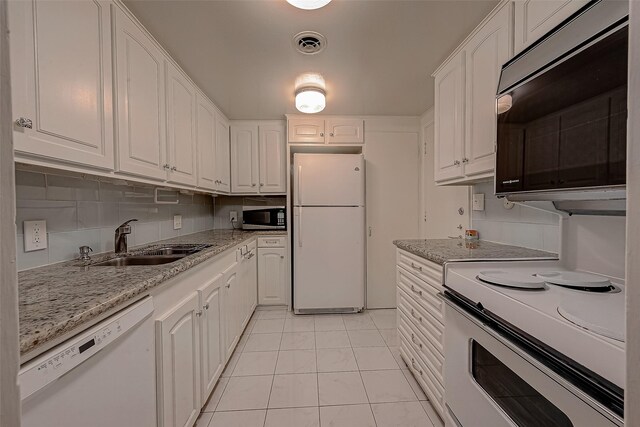 642 S Ripple Creek Dr Unit 642, Houston, TX 77057 - kitchen with white appliances, a sink, white cabinets, light tile patterned floors, and light stone counters