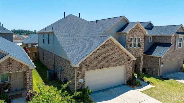 22614 Rosy Heights Trl, Tomball, TX 77377 - view of front of house featuring brick siding, driveway, and central air condition unit