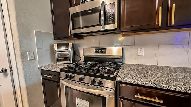 22614 Rosy Heights Trl, Tomball, TX 77377 - kitchen with appliances with stainless steel finishes, a textured wall, dark brown cabinets, backsplash, and dark stone counters