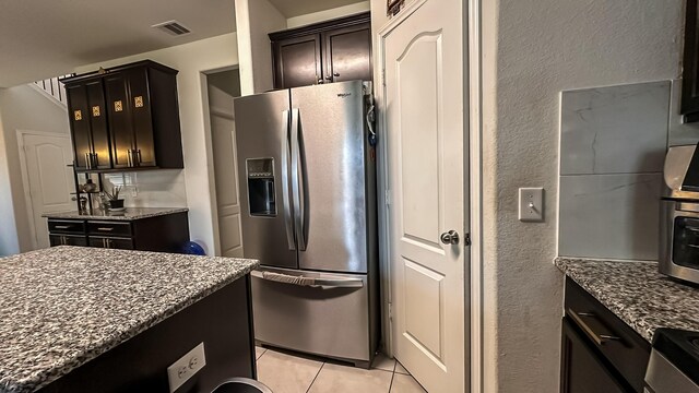 22614 Rosy Heights Trl, Tomball, TX 77377 - kitchen with stainless steel appliances, dark stone counters, light tile patterned flooring, and a textured wall