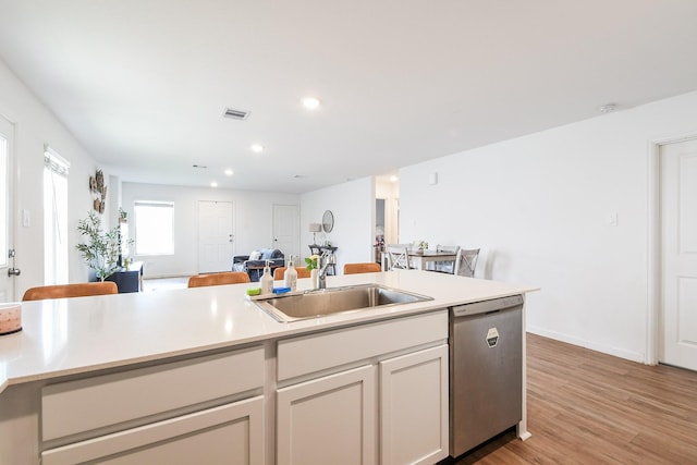 2728 Cadiz Bay Dr, Conroe, TX 77301 - kitchen featuring stainless steel dishwasher, a sink, light countertops, recessed lighting, and light wood-type flooring