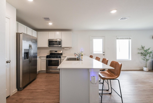2728 Cadiz Bay Dr, Conroe, TX 77301 - kitchen with appliances with stainless steel finishes, a sink, a peninsula, wood finished floors, and recessed lighting