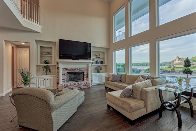 11872 Seashell Cir, Montgomery, TX 77356 - living area featuring a towering ceiling, baseboards, a brick fireplace, dark wood-type flooring, and built in shelves