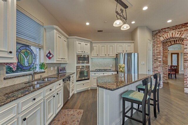 11872 Seashell Cir, Montgomery, TX 77356 - kitchen with appliances with stainless steel finishes, a sink, dark wood finished floors, dark stone counters, and recessed lighting