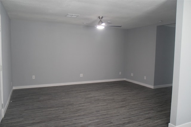 empty room featuring a ceiling fan, dark wood-style floors, and baseboards