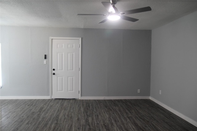 unfurnished room with ceiling fan, dark wood-type flooring, a textured ceiling, and baseboards