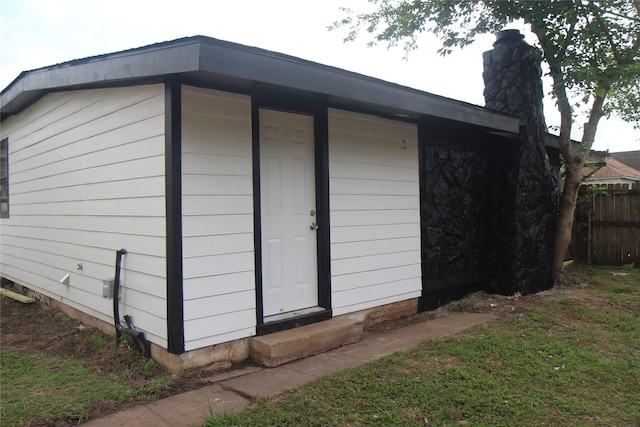 view of outbuilding with entry steps and fence