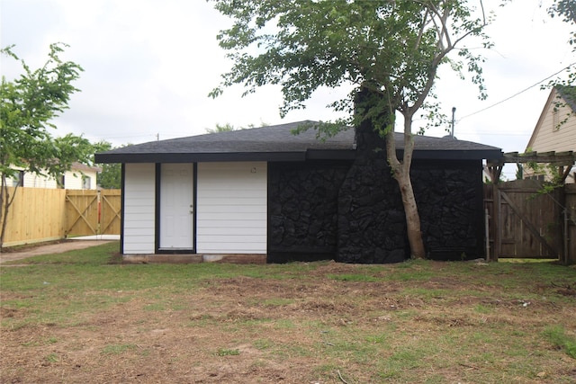 rear view of property with a gate and stone siding
