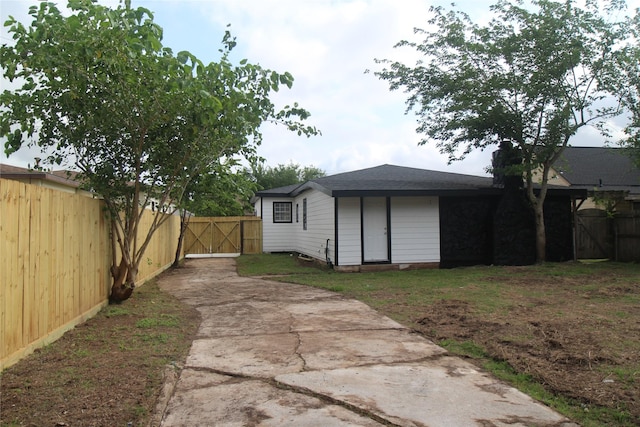 view of yard featuring a gate, fence, and concrete driveway