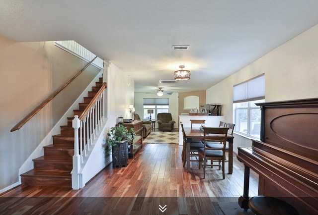 dining area with ceiling fan, wood finished floors, and stairs