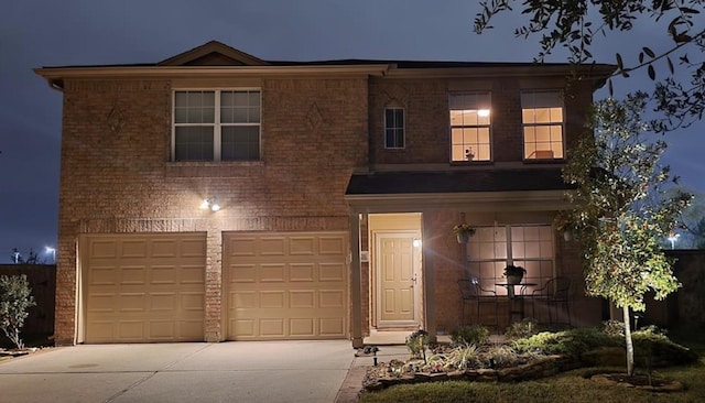 traditional-style house featuring driveway, an attached garage, and brick siding