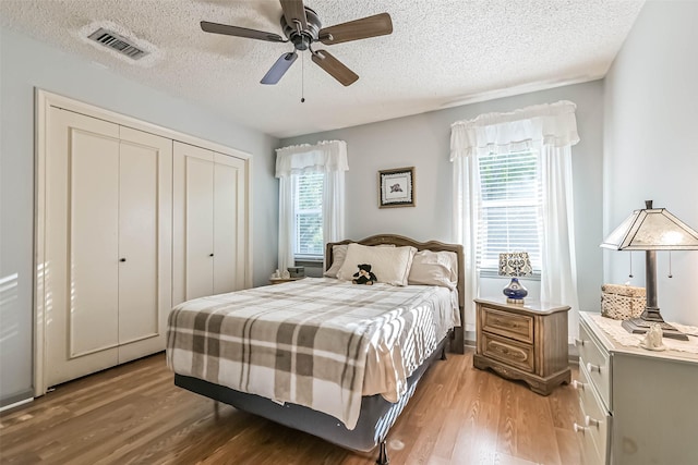 2607 E Pebble Beach Dr, Missouri City, TX 77459 - bedroom with light wood-type flooring, a textured ceiling, a closet, and ceiling fan