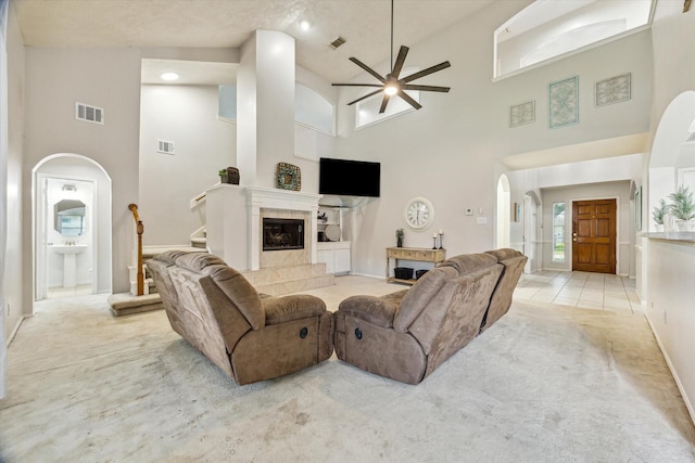 3413 Somerset Ln, Deer Park, TX 77536 - living area featuring arched walkways, a towering ceiling, light carpet, a ceiling fan, and baseboards