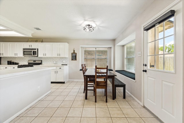 3413 Somerset Ln, Deer Park, TX 77536 - kitchen featuring appliances with stainless steel finishes, light countertops, tasteful backsplash, white cabinetry, and light tile patterned floors