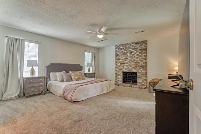 bedroom with a textured ceiling, carpet flooring, a fireplace, and a ceiling fan