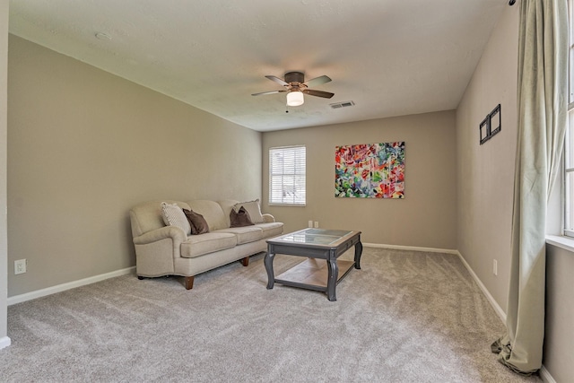 carpeted living area featuring ceiling fan and baseboards