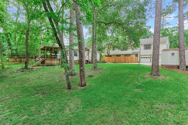 view of yard with stairs, a deck, and an attached garage