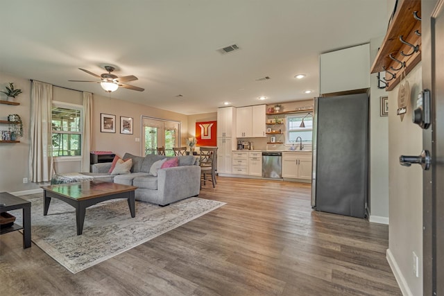 living area featuring light wood-style floors, ceiling fan, baseboards, and recessed lighting
