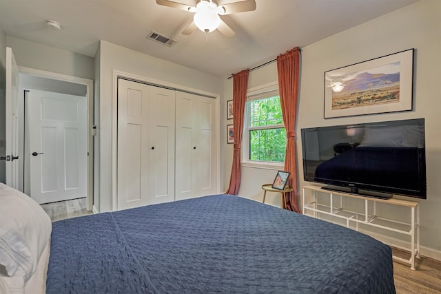 bedroom featuring wood finished floors, ceiling fan, a closet, and baseboards