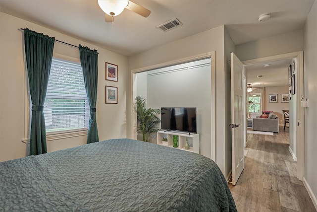 bedroom featuring wood finished floors, baseboards, and ceiling fan
