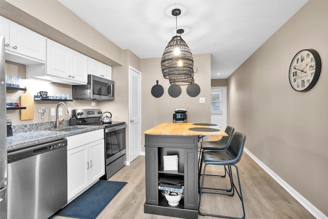 12900 Walden Rd Unit 715G, Montgomery, TX 77356 - kitchen with appliances with stainless steel finishes, a sink, light wood-style flooring, and baseboards