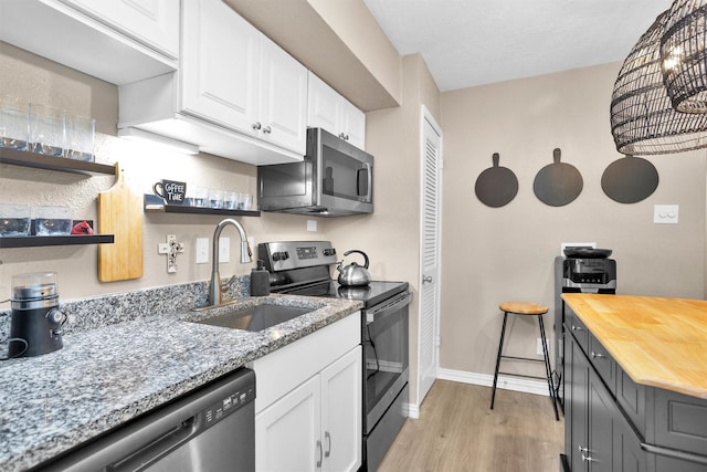 12900 Walden Rd Unit 715G, Montgomery, TX 77356 - kitchen featuring stainless steel appliances, a sink, butcher block countertops, and white cabinetry