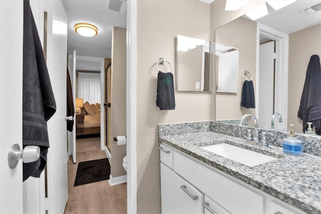 12900 Walden Rd Unit 715G, Montgomery, TX 77356 - bathroom with wood finished floors, ensuite bath, vanity, toilet, and baseboards