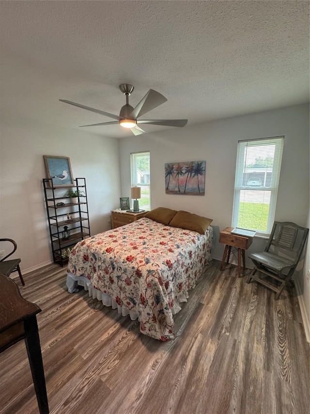 221 Marion Dr Unit 107C, Rockport, TX 78382 - bedroom with wood finished floors, a textured ceiling, baseboards, and ceiling fan