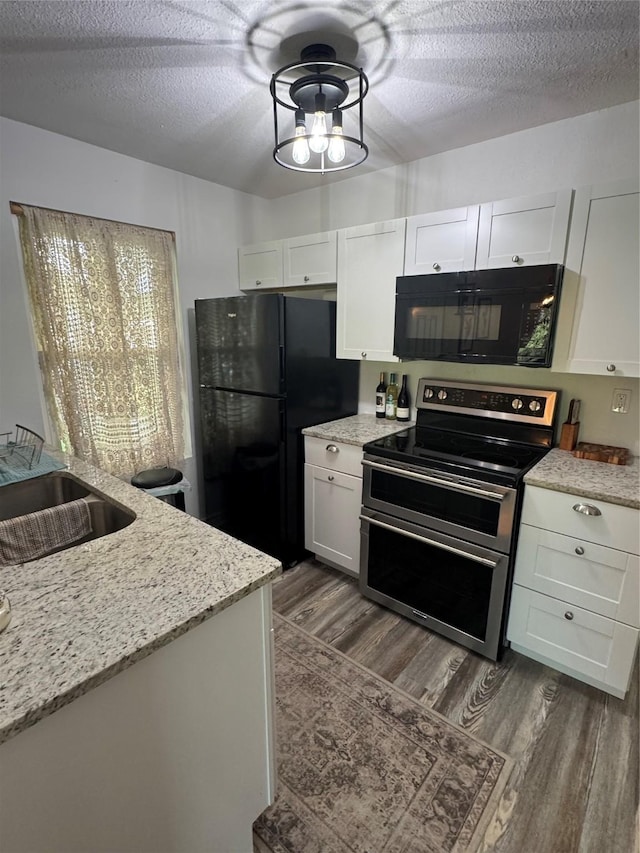 221 Marion Dr Unit 107C, Rockport, TX 78382 - kitchen featuring black appliances, a sink, dark wood-style flooring, white cabinetry, and a textured ceiling