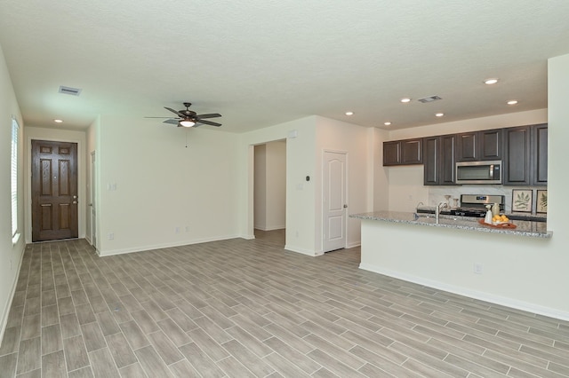 27638 Mesabe Dr, Magnolia, TX 77354 - kitchen with stainless steel appliances, ceiling fan, baseboards, recessed lighting, and open floor plan