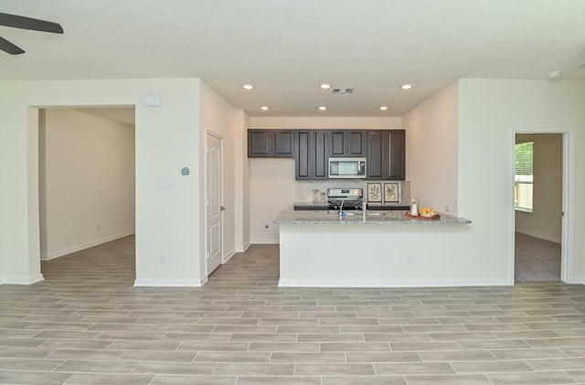 27638 Mesabe Dr, Magnolia, TX 77354 - kitchen featuring appliances with stainless steel finishes, a ceiling fan, recessed lighting, baseboards, and dark brown cabinets