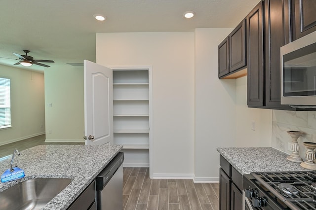 27638 Mesabe Dr, Magnolia, TX 77354 - kitchen featuring appliances with stainless steel finishes, a ceiling fan, dark brown cabinets, baseboards, and recessed lighting