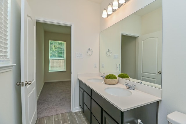 27638 Mesabe Dr, Magnolia, TX 77354 - bathroom featuring toilet, wood finished floors, double vanity, and baseboards
