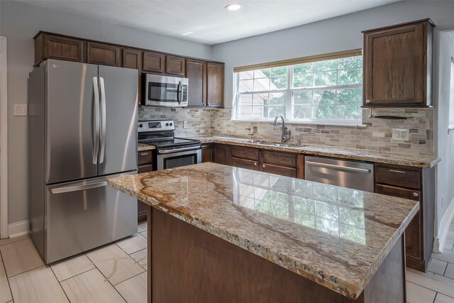 1109 Dismuke St, Houston, TX 77023 - kitchen with stainless steel appliances, a sink, decorative backsplash, light stone counters, and recessed lighting