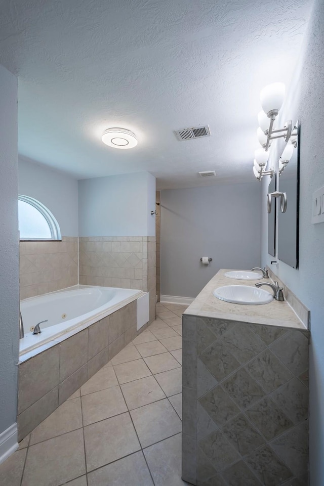 1109 Dismuke St, Houston, TX 77023 - full bathroom featuring a tub with jets, tile patterned floors, a textured ceiling, and double vanity