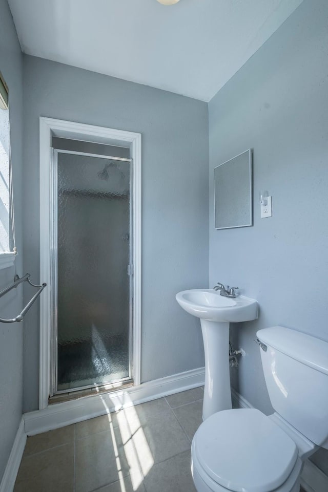 1109 Dismuke St, Houston, TX 77023 - bathroom with toilet, a shower stall, tile patterned floors, and baseboards