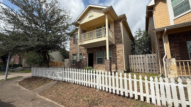 7346 Autumn Sun Dr, Houston, TX 77083 - view of front facade featuring a balcony, brick siding, and a fenced front yard