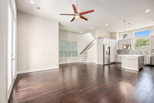 2422 Maufferd, Houston, TX 77009 - unfurnished living room with recessed lighting, dark wood-type flooring, a ceiling fan, and stairs