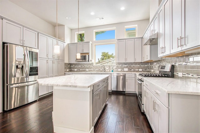 2422 Maufferd, Houston, TX 77009 - kitchen with stainless steel appliances, under cabinet range hood, a kitchen island, recessed lighting, and backsplash