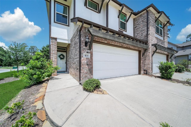 103 Skyshine Ct, Conroe, TX 77304 - view of front facade with a garage, stucco siding, concrete driveway, and brick siding