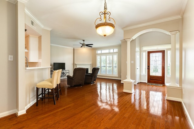 458 Mariners Dr, Kemah, TX 77565 - entrance foyer featuring decorative columns, a ceiling fan, crown molding, wood finished floors, and baseboards