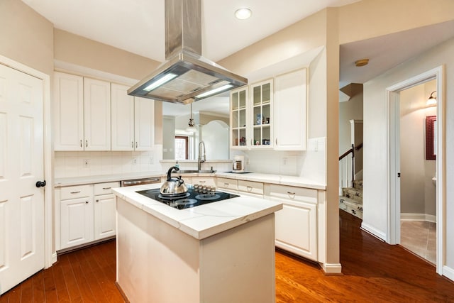 458 Mariners Dr, Kemah, TX 77565 - kitchen with black electric stovetop, island range hood, dark wood finished floors, a sink, and decorative backsplash