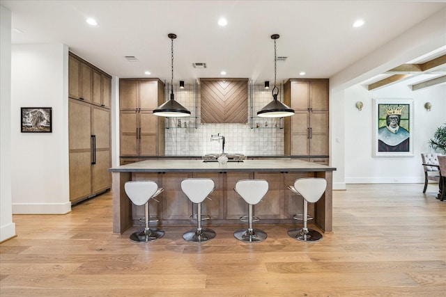 2017 W 14th St Unit A, Houston, TX 77008 - kitchen featuring decorative backsplash, an island with sink, baseboards, light wood-style floors, and recessed lighting