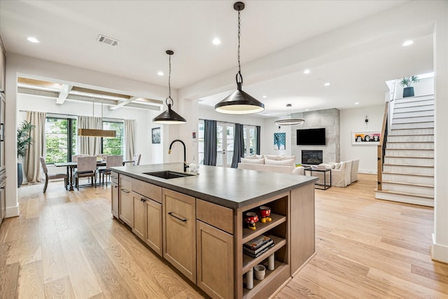 2017 W 14th St Unit A, Houston, TX 77008 - kitchen featuring a sink, recessed lighting, beam ceiling, light wood finished floors, and a center island with sink