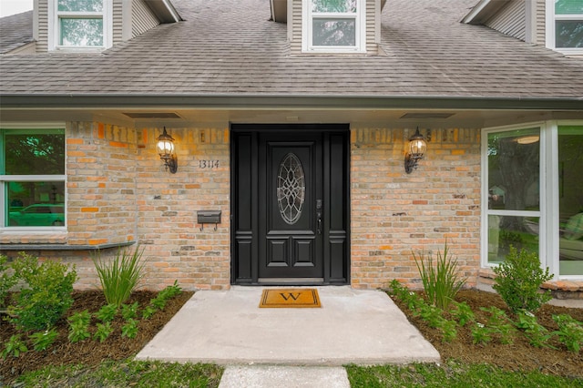 13114 Barryknoll Ln, Houston, TX 77079 - view of exterior entry featuring roof with shingles and brick siding