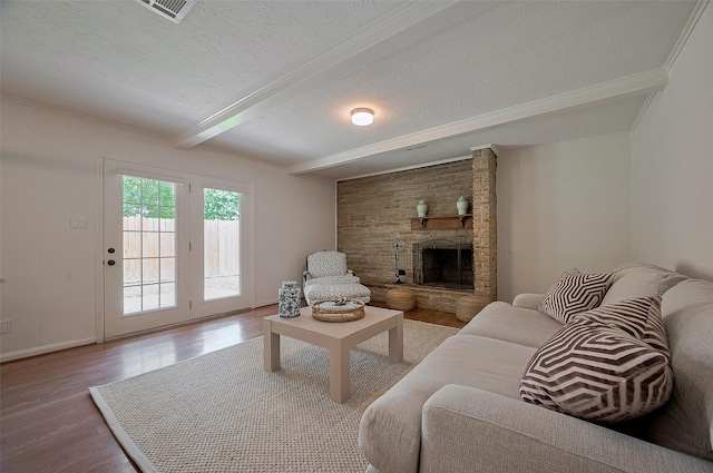 13114 Barryknoll Ln, Houston, TX 77079 - living room featuring wood finished floors, beam ceiling, a fireplace, a textured ceiling, and ornamental molding