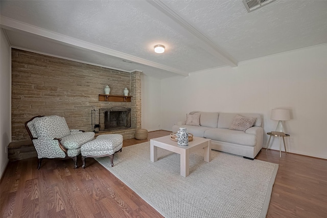 13114 Barryknoll Ln, Houston, TX 77079 - living room with a textured ceiling, beamed ceiling, wood finished floors, and a large fireplace
