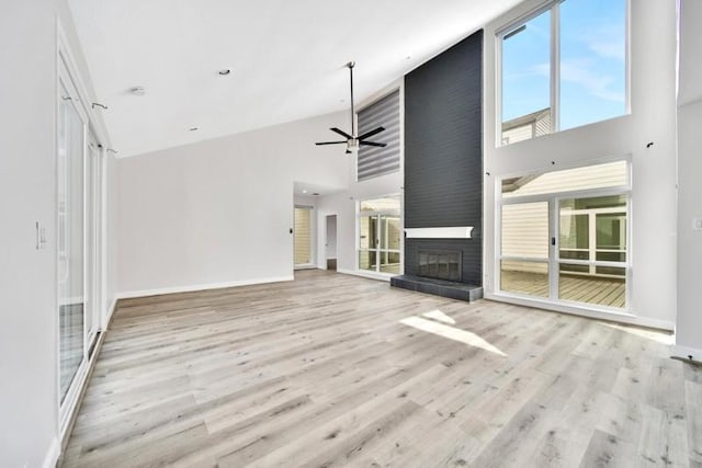 7607 Bankside Dr, Houston, TX 77071 - unfurnished living room featuring a towering ceiling, plenty of natural light, ceiling fan, wood finished floors, and a large fireplace
