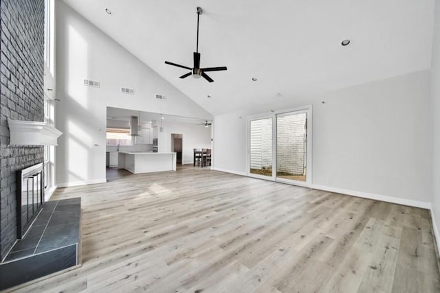 7607 Bankside Dr, Houston, TX 77071 - unfurnished living room with high vaulted ceiling, a ceiling fan, a fireplace, light wood finished floors, and baseboards
