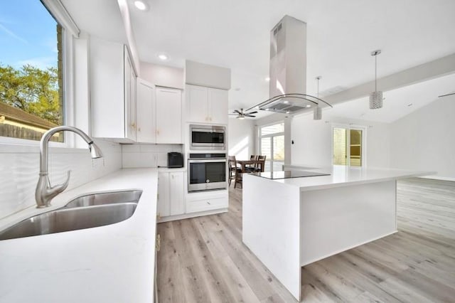 7607 Bankside Dr, Houston, TX 77071 - kitchen featuring stainless steel appliances, island range hood, a sink, white cabinets, and light wood finished floors
